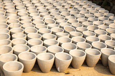 Dışarıda düzgünce dizilmiş el yapımı beton kaplar beton çömlek kurutma sürecini yakalıyor..