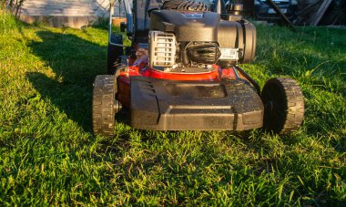 Yeşil çimlerin üzerinde çim biçme makinesi. Çimleri biçmek için makine.
