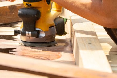 Öğütücüyle ahşap kapıları zımparalamak boyamadan önce kapıları temizlemek.