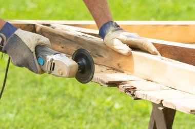 Öğütücüyle ahşap kapıları zımparalamak boyamadan önce kapıları temizlemek.