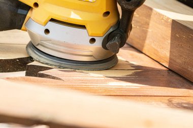 Öğütücüyle ahşap kapıları zımparalamak boyamadan önce kapıları temizlemek.