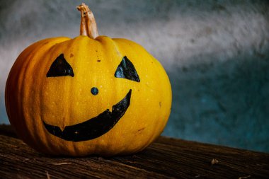 Gri arkaplanda ürkütücü suratlar çizilmiş balkabakları. Cadılar Bayramı