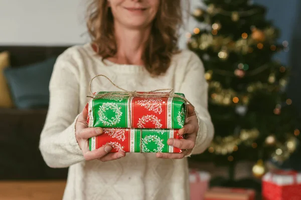gift giving woman hand holding a gift box in a gesture of giving  Christmas concept