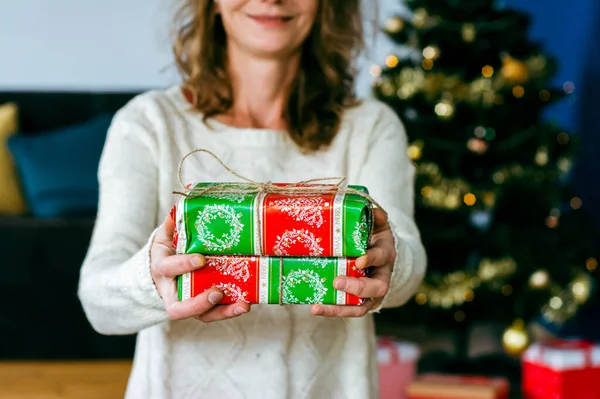 gift giving woman hand holding a gift box in a gesture of giving  Christmas concept