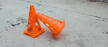 İnşaat alanının beton zemininde turuncu turuncu güvenlik konisi
