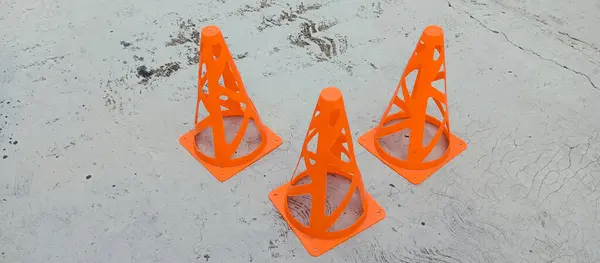 ... yerdeki turuncu plastik koniler.