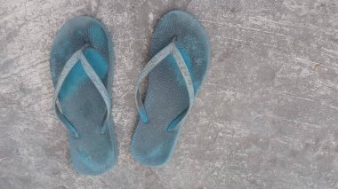 Çimentoda eski püskü ayakkabılar.