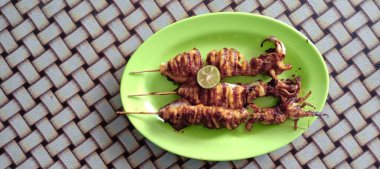 Tayland usulü kızarmış kalamar, ızgara kalamar, kızarmış kalamar, yeşil yapraklı.