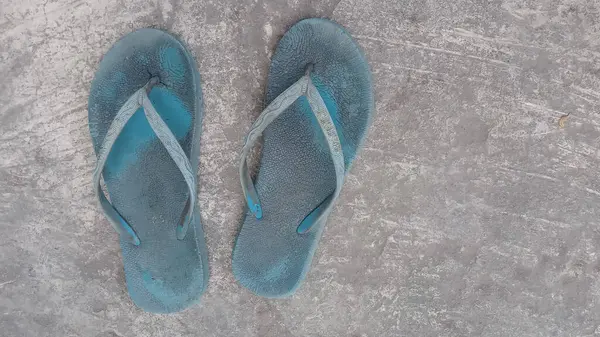 Çimentoda eski püskü ayakkabılar.