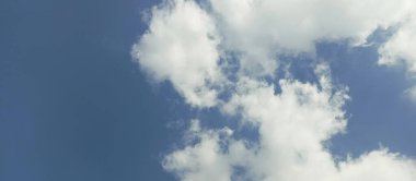 Mavi gökyüzünde beyaz tüylü kümülüs bulutları
