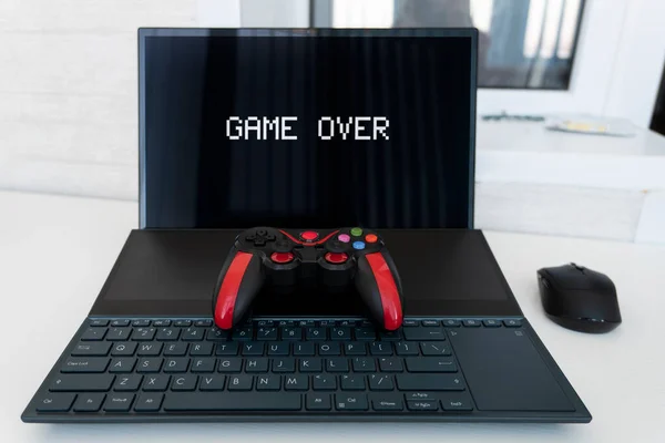 ゲーム機のジョイスティックは黒と赤ラップトップです ゲーム業界の概念と楽しい家庭の娯楽 — ストック写真