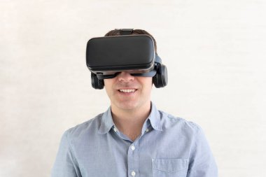 İnsanlar ve teknoloji metaevren konsepti. Mutlu genç adamın portresi, pozitif gülümseyen adam, modern bir cihaz takıyor sanal gerçeklik maskesi takıyor ya da 3D, AR, VR gözlükleri, oyun oynuyor..