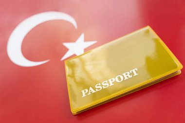 Pasaportlu bir hindi bayrağı. Seyahat vizesi ve vatandaşlık konsepti. Ülkede oturma izni. Bayrağın üzerinde yazılı pasaportu olan sarı bir belge var. Kapat, üst görünüm