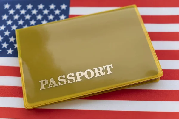 Flag of USA with passport. Travel visa and citizenship concept. residence permit in the country. a yellow document with the inscription passport is on the flag. Close up, top view