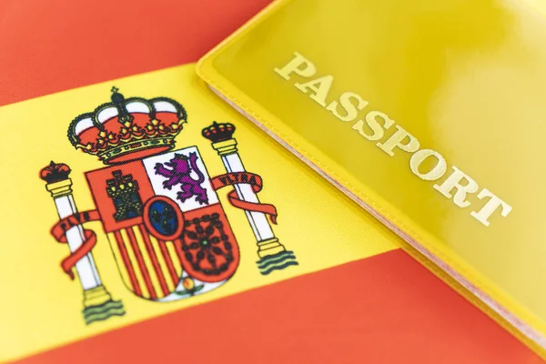 Flag of spain with passport. Travel visa and citizenship concept. residence permit in the country. a yellow document with the inscription passport is on the flag. Close up, top view