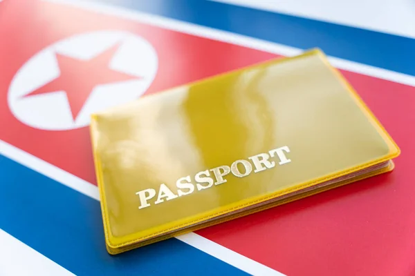 Flag of north korea with passport. Travel visa and citizenship concept. residence permit in the country. a yellow document with the inscription passport is on the flag. Close up, top view