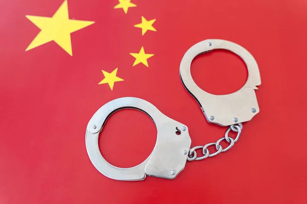 China flag and police handcuffs. The concept of observance of the law in country and protection from crime