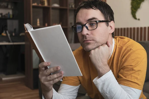 一个戴眼镜的英俊的成年人 坐着看书 — 图库照片
