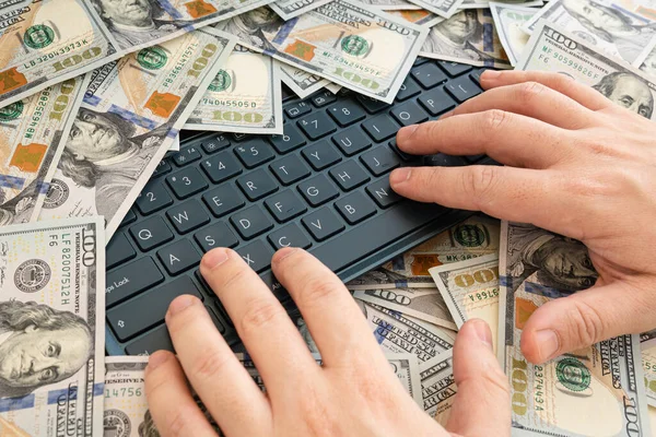 finger presses the key on the laptop on the background of money. make a profit from online trading. High salary to find a specialist. The concept of training through an intern