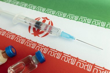 Farmakoloji ve Tıp İranı kavramı. Coronavirus covid aşısı. Aşı ampulleri, ulusal bayrağın arka planına karşı şırınga. Ulusal farmakoloji endüstrisi.