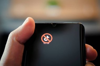 Siyah bir akıllı telefon ekranında üstü çizilmiş bir simge. Uygulama tik tok 'u becerme konsepti. 1 Nisan 2022. Barnaul. Rusya