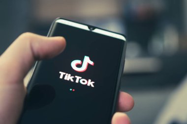 The logo of Tik Tok - a popular application for watching videos on a black smartphone. Barnaul. Russia. February 4, 2021 clipart