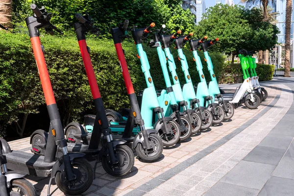 Otoparkta arka arkaya bir sürü elektrikli scooter var. Şehir bisiklet kiralama sistemi, sokakta halka açık scooter 'lar.