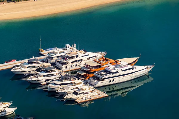 fast boats and luxury yachts are parked in the port at the pier near the beach. View from above.