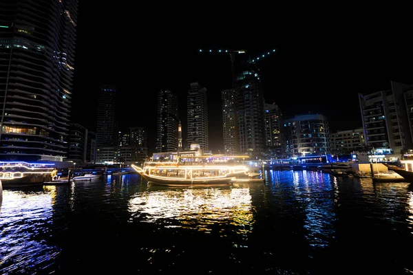 ドバイ マリーナは ボートのタイムラプス Hyperlapse ヨットとベイします 夜に照らされた高層ビルが運河の水に反映 — ストック写真