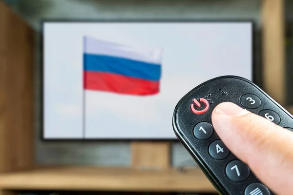 Controlul Distanță Mâna Unui Fundalul Unui Televizor Unui Steag Rusesc — Fotografie, imagine de stoc