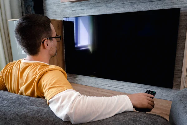Человек Смотрит Телевизор Включает Плазменный Телевизор Плоским Экраном Направляет Пульт — стоковое фото