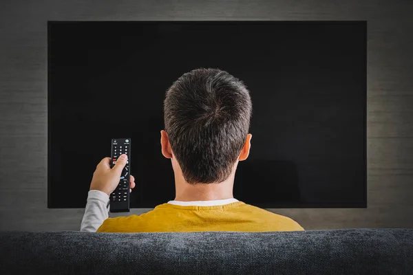 Facet Ogląda Telewizję Włącza Telewizor Plazmowy Wskazuje Pilotem Pusty Ekran — Zdjęcie stockowe