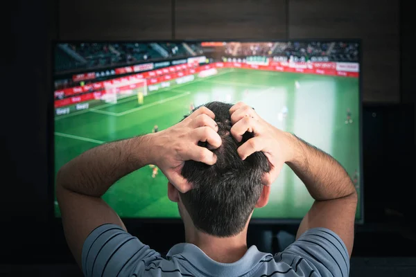 目標だ 自宅でテレビでサッカーの試合を見ている男 夜にサッカーを見ている感情的なファン 後ろからの眺め — ストック写真