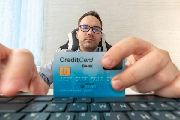 Business online shopping and online banking. Customer shopping online pay by credit card. A joyful businessman enters credit card details for an online purchase