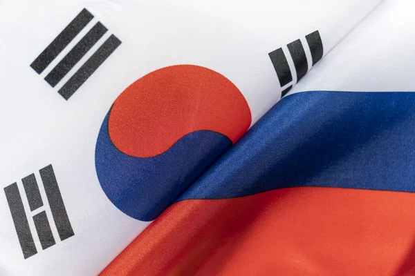 Flags of the south korea and Russia. The concept of international relations between countries. Sanctions against Russia. The state of governments. Friendship of peoples.