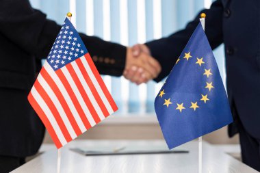 Avrupa Birliği ve Amerika Birleşik Devletleri 'nin siyasi bayrakları masada. Müzakere konsepti, ülkelerin işbirliği ve işbirliği. Hükümetler arasında anlaşma.