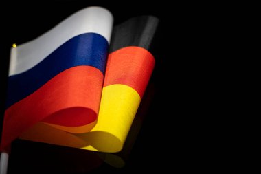Siyah arka planda Almanya ve Rusya bayrakları. İki ülke arasındaki etkileşim veya karşı etki kavramı. Uluslararası ilişkiler. politik görüşmeler. Boşluğu kopyala.