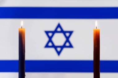 Mourning in the country. A burning candle on the background of the israel flag. Victims of cataclysm or war concept. memorial day, remembrance day. National mourning. clipart