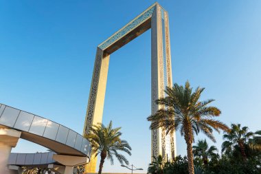 Dubai, BAE. 25 Kasım 2022: Dubai Golden Frame Zabeel Park 'ta yer alan en iyi yeni şehir simgesi. Altın çerçeveye ve palmiye ağacına bak