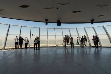 Dubai, Birleşik Arap Emirlikleri. 29 Kasım 2022 'de çatıdaki bir gökdelenin tepesinde. Suni Palm Jumeirah Adası manzarası. Ziyaretçiler avucundaki güzel manzaranın tadını çıkarırlar.