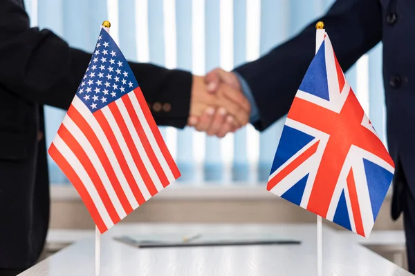 Political flags of United Kingdom and United States of America on table. concept of negotiations, collaboration and cooperation of countries. agreement between the governments.