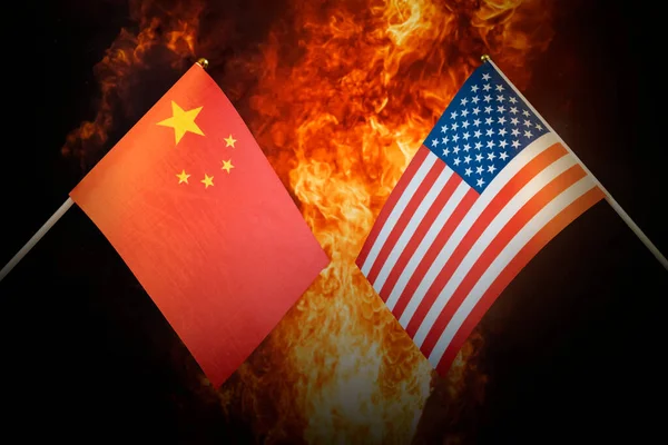Flags of China and United States of america against the background of a fiery explosion. The concept of enmity and war between countries. Tense political relations.