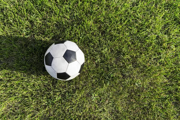 サッカー場の明るい緑の芝生の上で古典的なサッカーボールのトップビュー 夏のスポーツ スペースのコピー — ストック写真