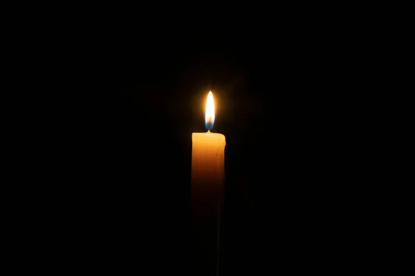 孤立的黄蜡烛在黑色背景上燃烧 记忆和悲伤的概念 — 图库照片