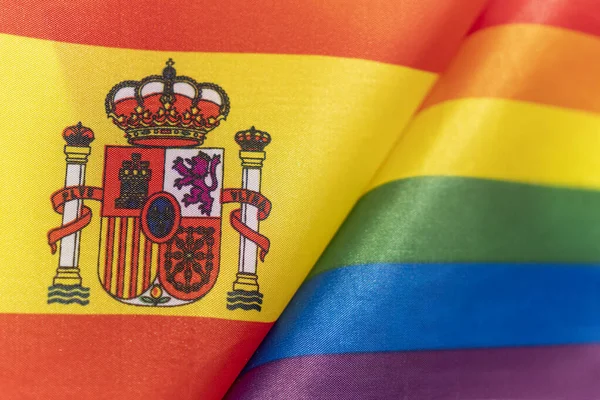 spanish flag and flag of LGBT community. The problem of the rights of sexual minorities in the country. Protection and infringement of human rights. non-traditional relations and politics concept.