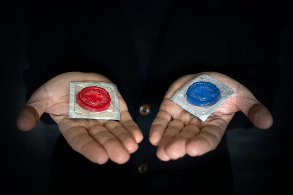 Conceito Escolha Preservativo Vermelho Azul Mão Homem Sobre Fundo Escuro — Fotografia de Stock