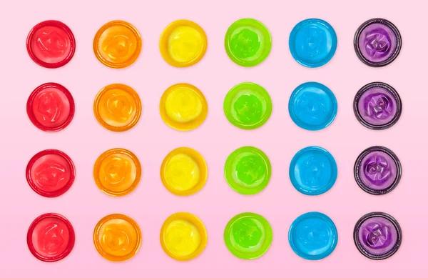 섹스의 질환으로부터 분홍색 배경에 무지개 색깔로 놓여져 콘돔들 — 스톡 사진