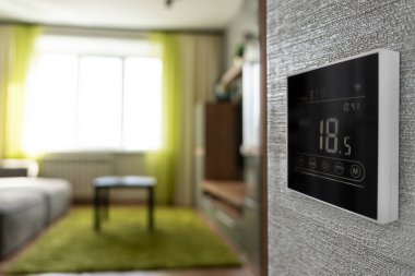 Evde sıcaklık kontrolü için programlanabilir termostat. Kışın apartman dairesinde sıcaklık düşük. Oda sıcaklığı 10 derece. Duvardaki elektronik termometre
