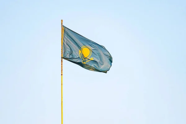 Kazakhstan flag on blue sky background. close up waving flag of Kazakhstan. flag symbols of Kazakhstan.