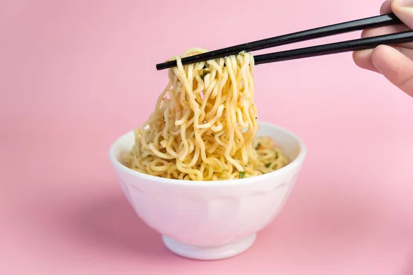 ピンクの背景に麺の白いボウル 高速安価な食品 中国のインスタントラーメン アジア料理 — ストック写真